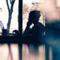 blurred abstract image of person sat at a laptop